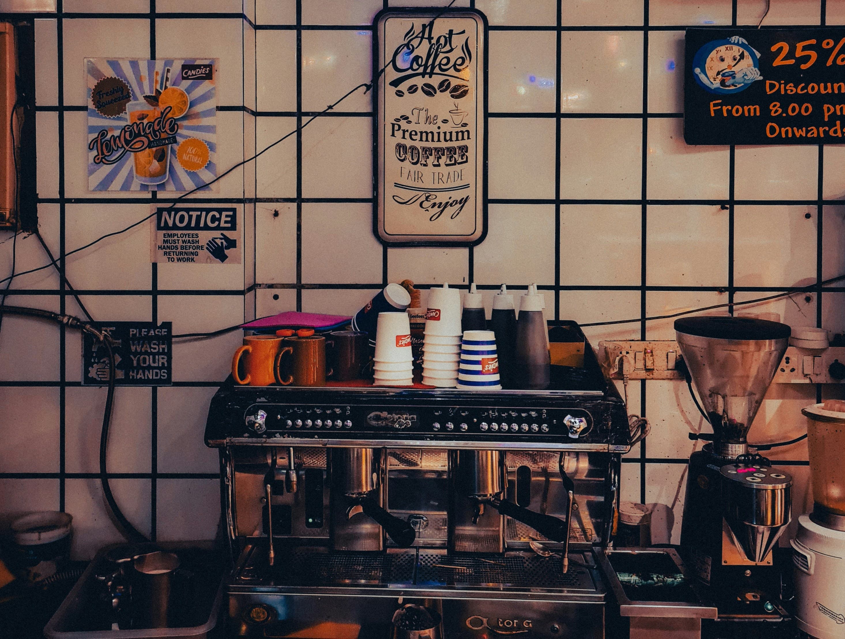 A coffee machine sitting in a kitchen next to a tiled wall