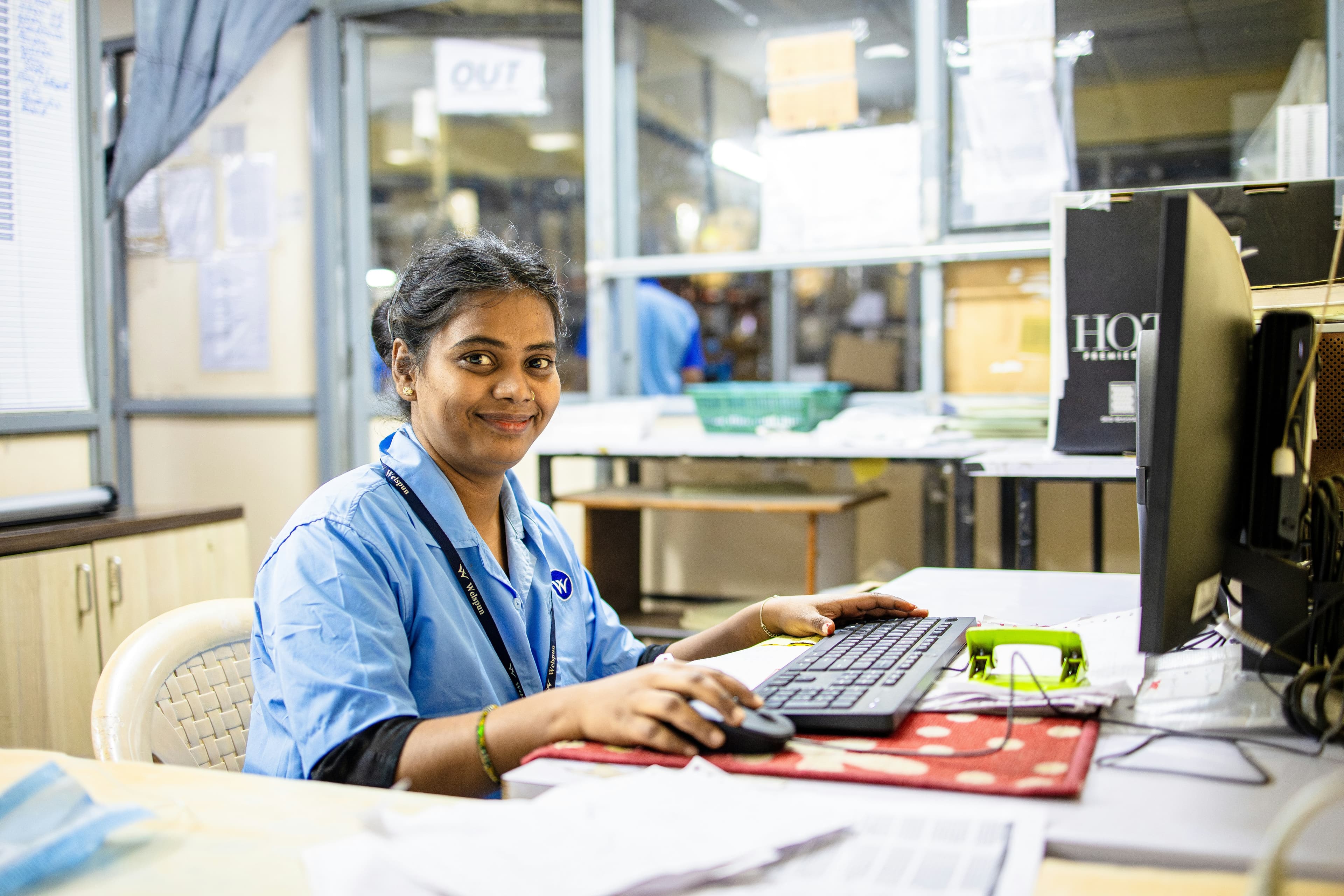 A woman works at her computer smiling