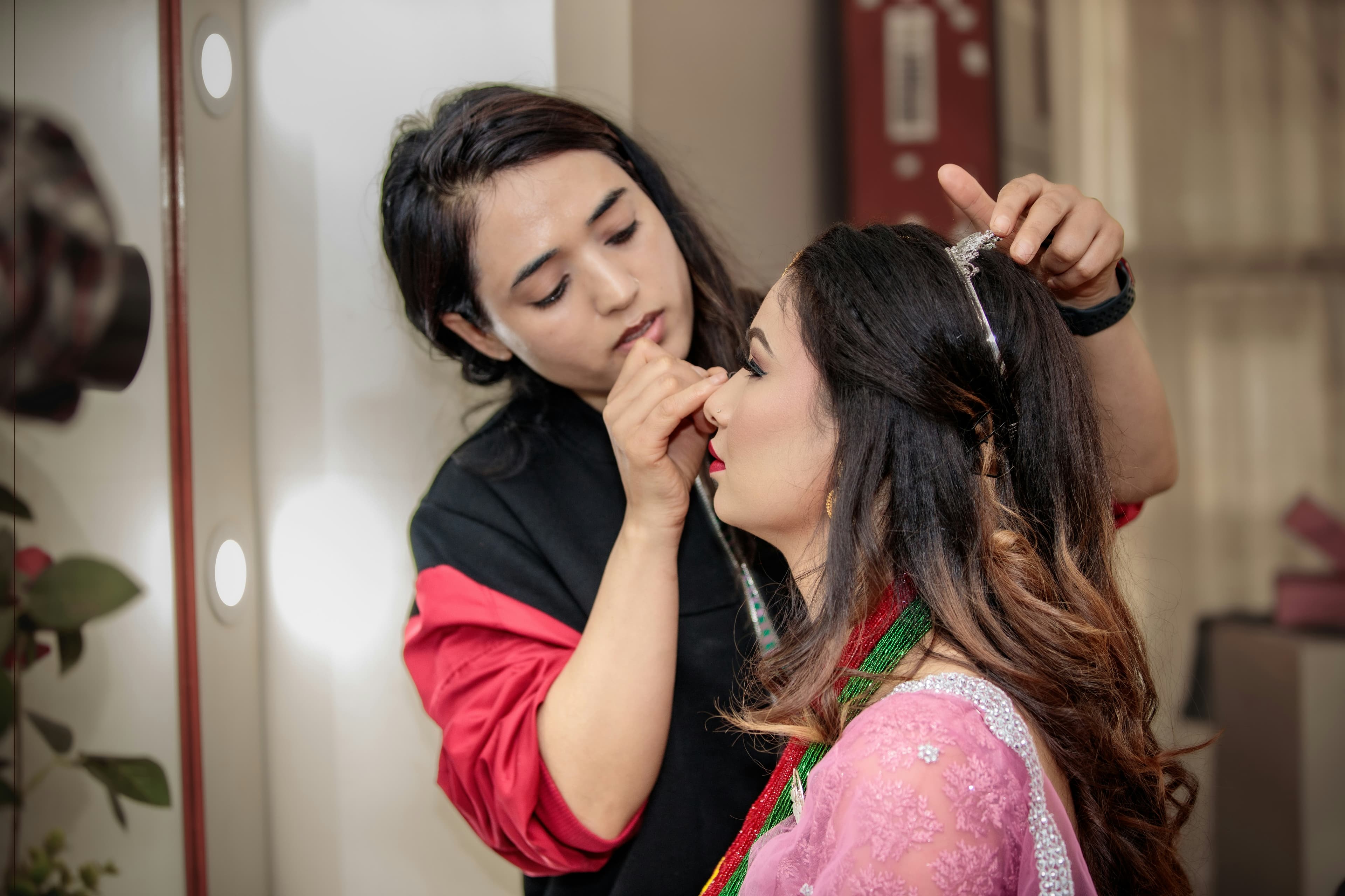 Nepali Bride in Traditional Wedding Attire doing make up in parlor