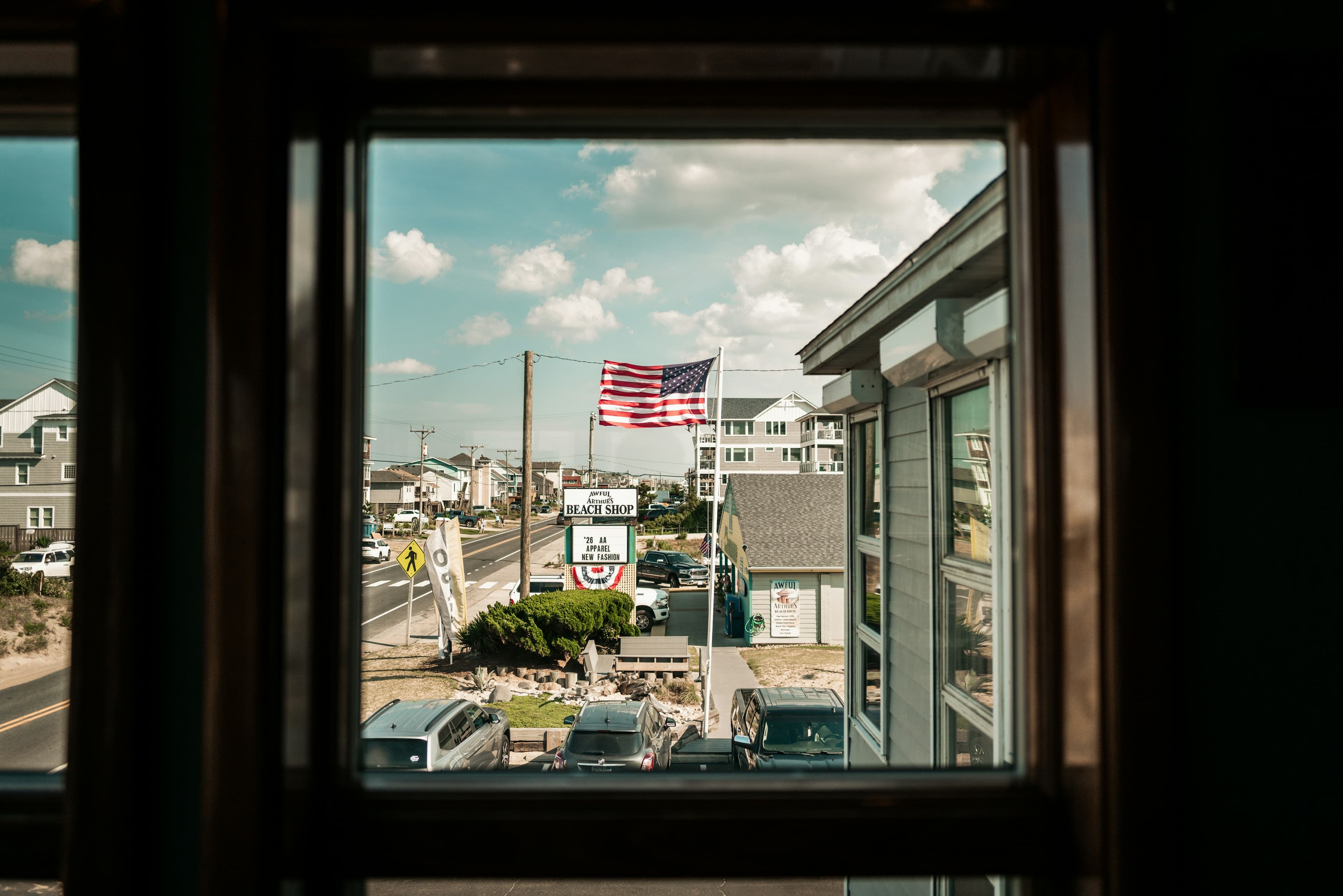 Coastal town view with american flag framed by a window